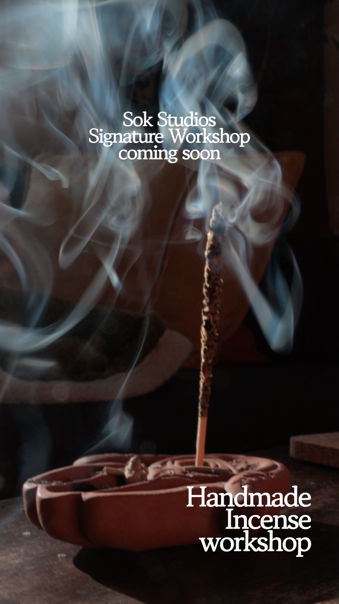Burning handmade incense stick with smoke rising during SOK Studios workshop